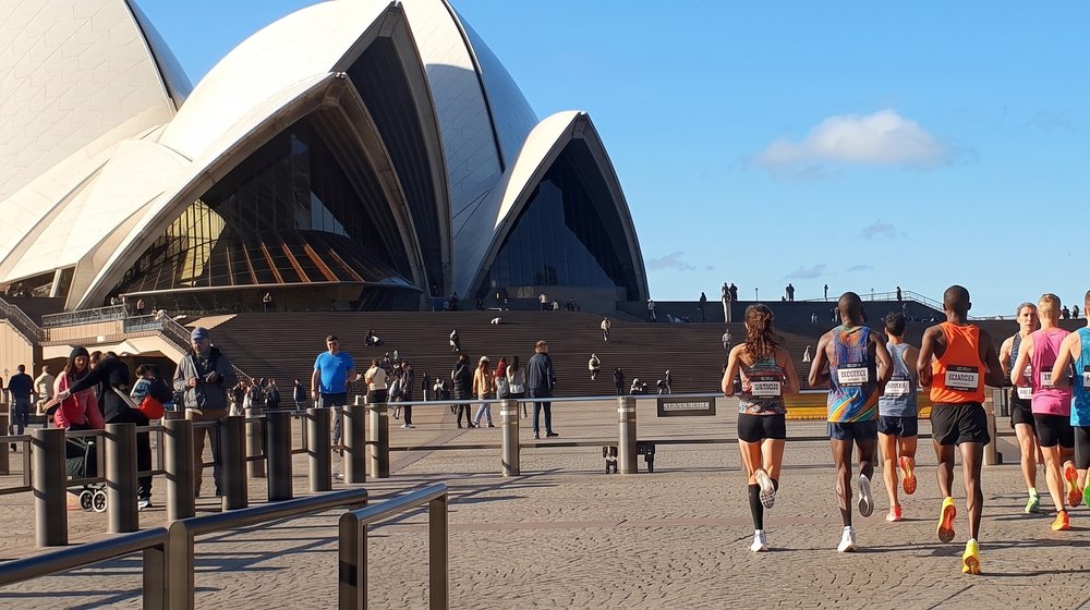 Marathon runners approaching the Sydney Opera House forecourt finish line